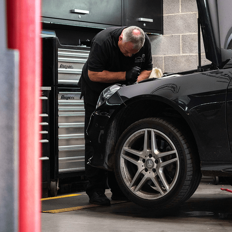 employee working under the bonnet of a car