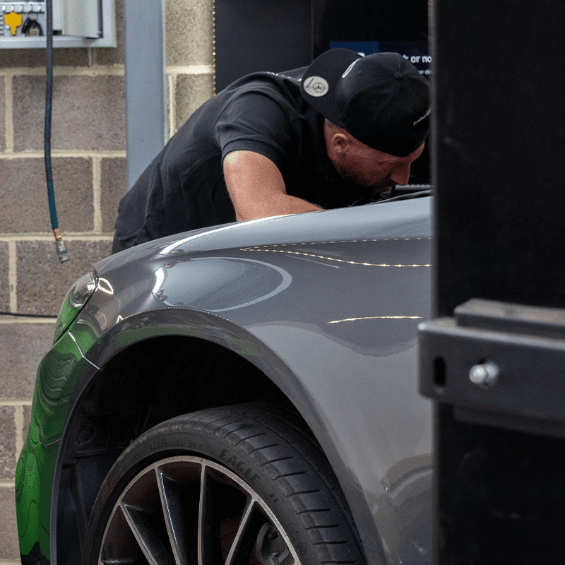 employee working in engine bay of mercedes